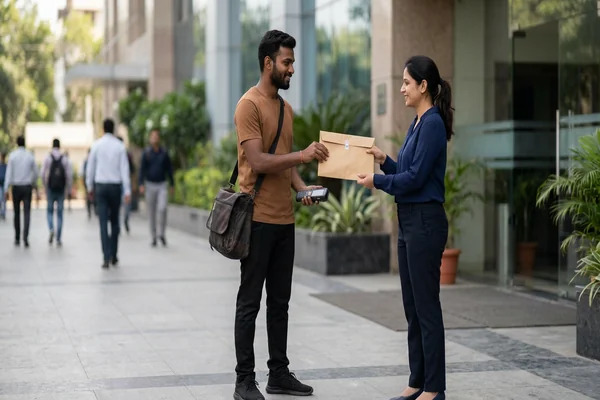 Courier executive collecting sealed legal document envelope outside office in Jabalpur